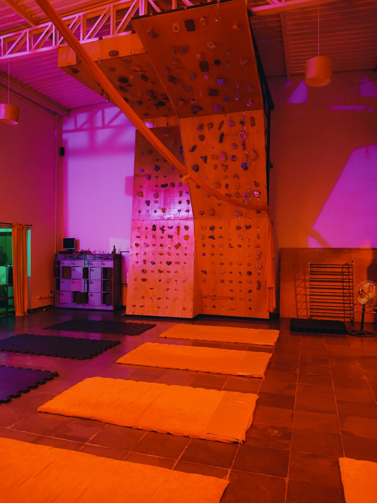 Espaço com mats e parede de escalada